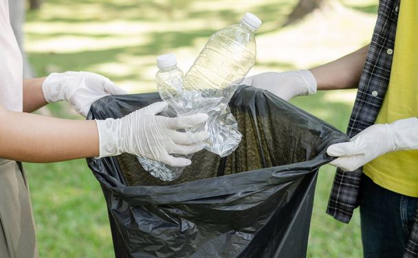 sběr odpadků, dobrovolnický tým sbírat plastové láhve, dávat odpadky do černých pytlů na odpadky uklidit v parcích, vyhnout se znečištění, být přátelský k životnímu prostředí a ekosystému. - Fotografie, Obrázek