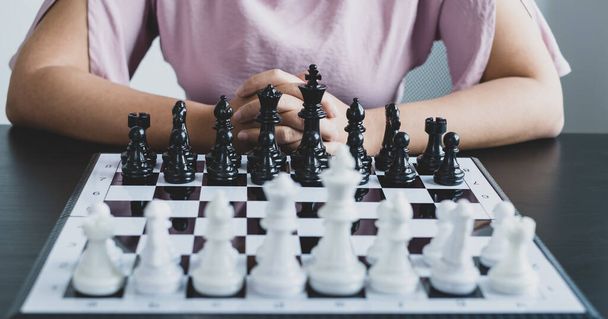 Het schaakbord toont leiderschap, de hand van de zakenvrouw in beweging, schaken in competitie toont leiderschap, volgers en zakelijke successtrategieën. - Foto, afbeelding