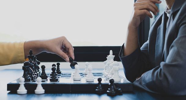 Las manos de las empresarias dos personas que mueven ajedrez en competiciones de ajedrez demuestran liderazgo, seguidores y planes estratégicos, procesos de construcción de éxito empresarial y trabajo en equipo. - Foto, Imagen
