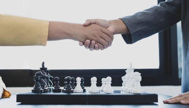 shake hands, businesswomen two people moving chess in chess competitions demonstrate leadership, followers, and strategic plans, business success building processes, and teamwork. - Photo, Image