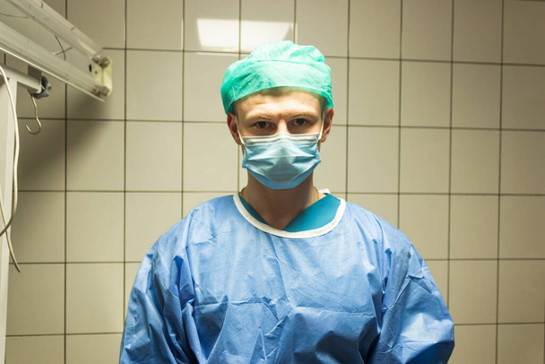 Portrét veterinárního lékaře v uniformě - modré šaty, klobouk a maska. Připravte se na operaci na operačním sále. Koncepce medicíny a zdravotní péče.  - Fotografie, Obrázek