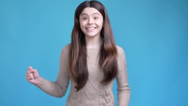 Latin kid lady rejoice lottery win fist up isolated blue color background - Felvétel, videó