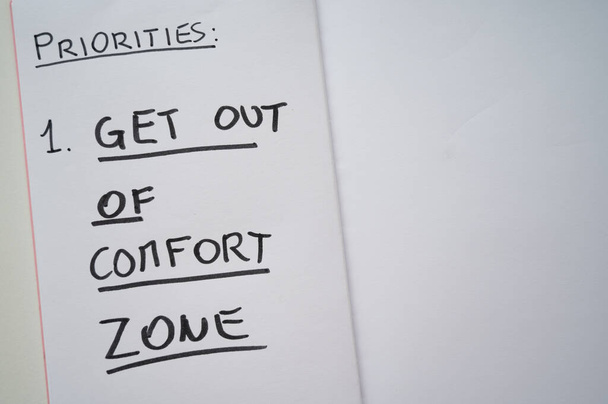 Pagina del diario con il testo "priorità: uscire dalla zona di comfort". Cambiamento dello stile di vita - Foto, immagini