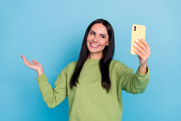 Portrait of cheerful lady make selfie arms palm hold demonstrate empty space isolated on blue color background - Foto, Bild