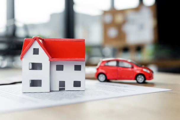 modelo de casa de cartón y coche de juguete en el documento, concepto de impuestos - Foto, imagen