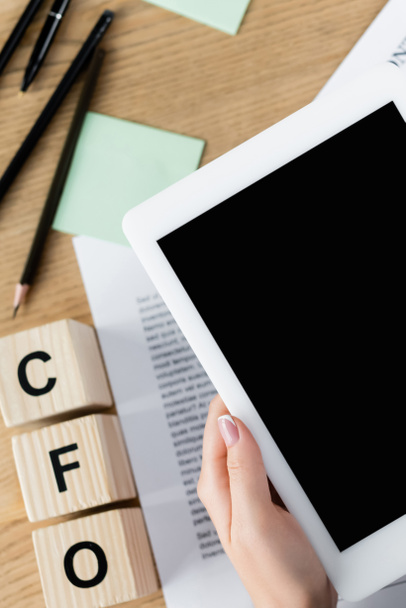 abgeschnittene Ansicht einer Geschäftsfrau mit digitalem Tablet und leerem Bildschirm über cfo-Buchstaben auf Würfeln - Foto, Bild