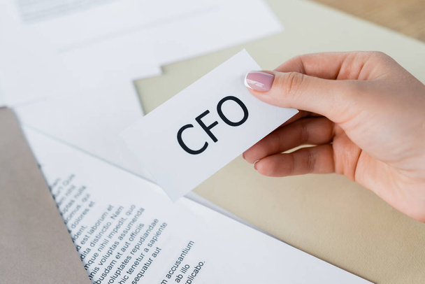 cropped view of woman holding paper with cfo lettering  - Photo, Image