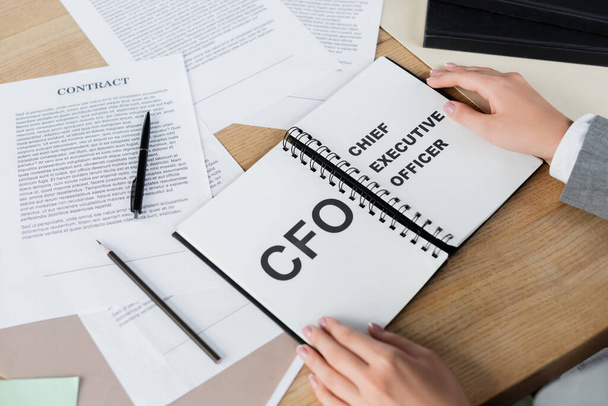 cropped view of woman holding notebook with cfo and chief executive officer lettering  - Foto, Imagem