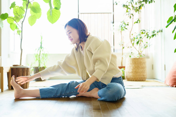 Asian woman stretching in the room - 写真・画像