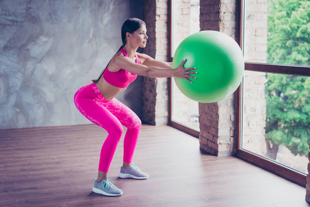 Profile side photo of lady sportsman doing aerobics hold fit ball gear effort endurance in modern loft - Фото, изображение