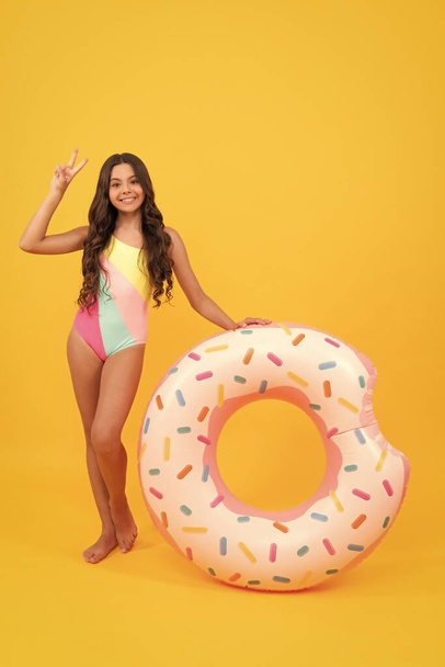 vacaciones de verano. chica feliz en traje de baño anillo de donut inflable. adolescente con anillo de natación. - Foto, Imagen