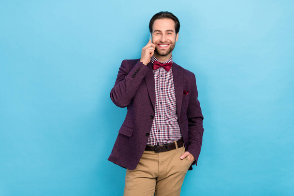 Photo of young cheerful guy tell listen communication mobile manager isolated over blue color background - Foto, Imagem