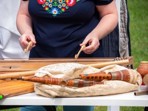 Zenész nő játszik tsymbaly etnikai hangszer ütő két verők. Ukrán változata a kalapács dulcimer, kordofon trapéz doboz fém húrok. Népzenei fesztivál Lviv, Ukrajna. - Fotó, kép