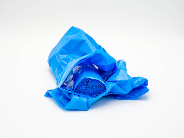 Plastic trash bags rolled up, blue on white background - Foto, afbeelding