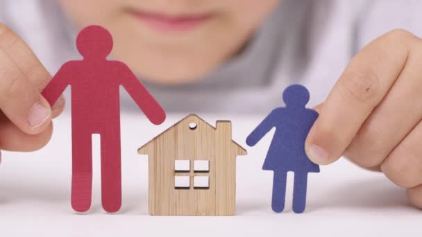 Papier man en meisje in de handen van een jongen dicht bij het houten huis.  - Video
