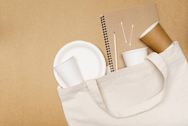 Eco friendly concept, notebook with pencil and food container in eco bag on wooden background. - Photo, image