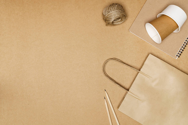 Ekologiczna koncepcja, Torba papierowa z kubkiem i notebookiem ołówek z jutową liną na drewnianym tle. - Zdjęcie, obraz