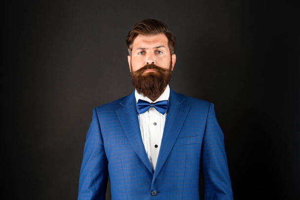 serious man in blue tuxedo bow tie. man in formalwear on black background. male formal fashion - Photo, Image