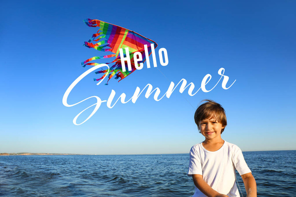 かわいい男の子が海のビーチで虹の凧を飛んでいます。こんにちは、夏 - 写真・画像