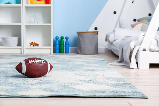 Rugby ball on floor in children's room - Photo, image