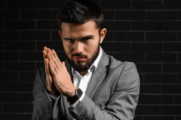 Bearded businessman with stylish wristwatch on dark background - Фото, изображение