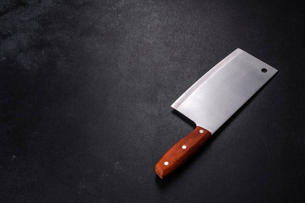 Um machado para cortar carne em um fundo de concreto escuro. Preparação de carne para um delicioso bife - Foto, Imagem