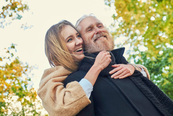 Joyful couple of old man and young woman outdoors - Zdjęcie, obraz