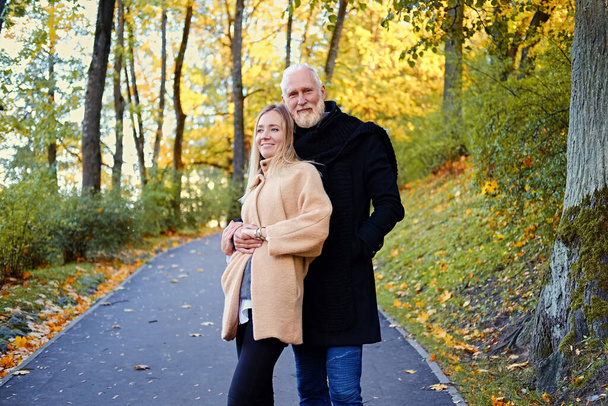 Petite-fille et grand-père joyeux sur la promenade en bois d'automne - Photo, image