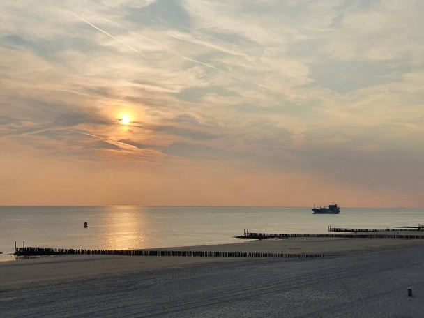 Coucher de soleil entre nuages avec vue sur la plage jusqu'à la mer - Photo, image