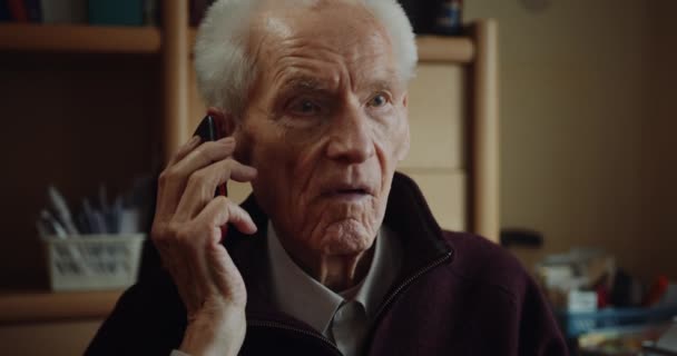 senior man aan het praten op mobiele telefoon - Video