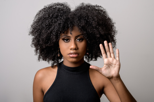 Черная женщина делает жест с открытой рукой, осуждает нападение, моральные домогательства, трусость, насилие в отношении женщин - Фото, изображение