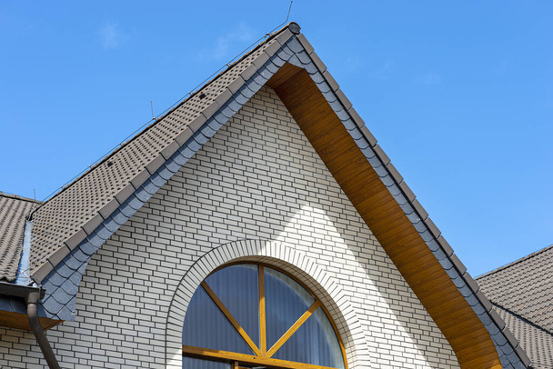 L'église a un soffit en PVC classique qui imite le bois avec une façade en brique blanche. - Photo, image