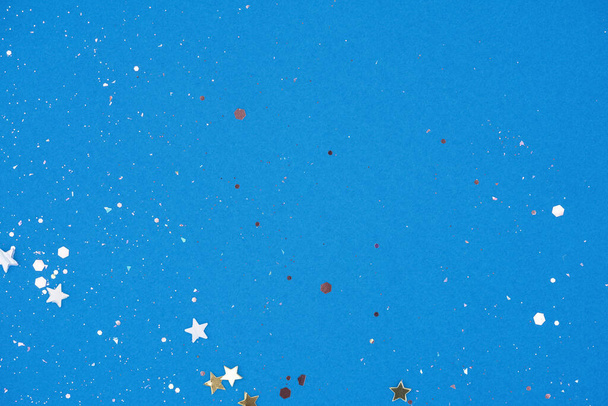 Fondo abstracto festivo con destellos de estrellas y purpurina en azul. Fondo brillante con espacio de copia para su proyecto - Foto, imagen
