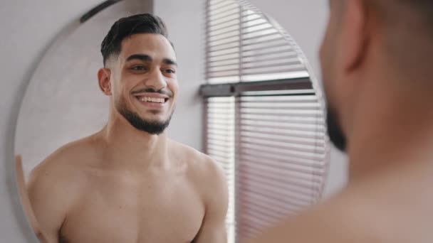 Cerca de reflexión masculina en espejo guapo 30s unshaven confiado árabe indio desnudo hombre desnudo en baño sonriente toothy sexy sin camisa barbudo millennial hipster chico sonrisa feliz preparándose hasta la fecha - Metraje, vídeo
