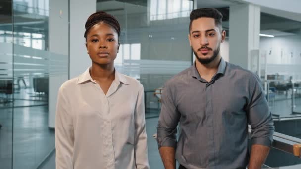 ポートレートビジネスの人々アフリカの女性ビジネス女性と大人のアラビア人の男性の上司のマネージャーがオフィスに立って、腕を組んでカメラのポーズをとっています。会社の職場で2人の成功した会社の労働者 - 映像、動画