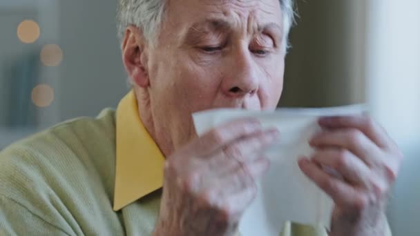 Vanha valkoihoinen 60s mies sairas kärsimys vuotiaiden kypsä vanhempi sairas 70s miespotilas isoisä aivastaa vuotava nenäliinoja räkä paperi kudos kausiluonteinen allergia oireet sairaus hengitystieinfektio kotona - Materiaali, video