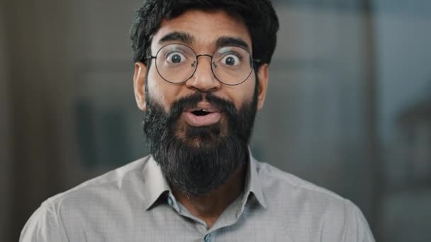 mężczyzna portret niespodzianka emocje entuzjazm zaskoczony szok arabski zdumiony człowiek w okulary zrobić wielkie oczy indyjski biznesmen zwycięzca zademonstrować wow emocje wyraz twarzy powiedzieć wow szczęście triumf - Materiał filmowy, wideo