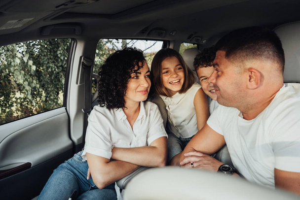 Mãe e pai com duas crianças adolescentes em uma viagem de fim de semana, feliz família de quatro membros viajando de carro Minivan - Foto, Imagem