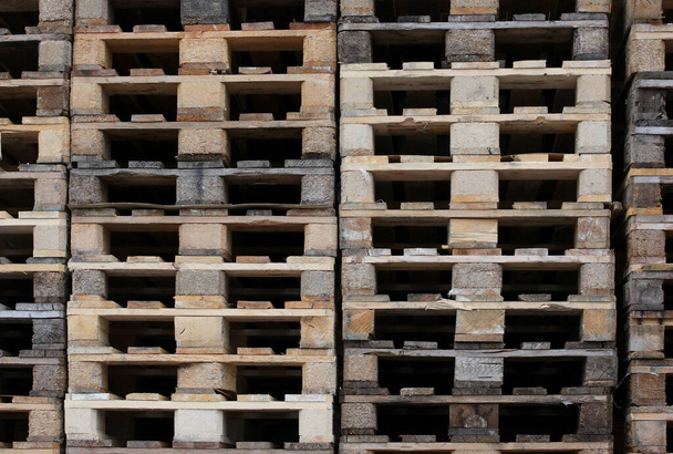 φόντο ξύλινων παλετών στοιβαγμένων στην αποθήκη μιας μεταφορικής εταιρείας χωρίς τα εμπορεύματα - Φωτογραφία, εικόνα