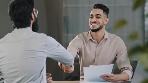 Two successful diverse business men colleague arabian salesman banker male manager shaking hand client customer accept common project successful corporate partnership deal agreement at office meeting - 映像、動画