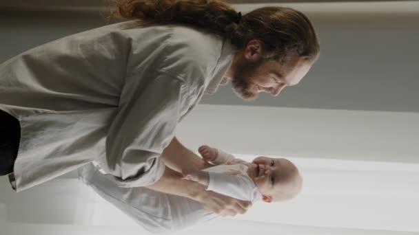 Vertikální pohled kavkazský dospělý otec milující péči tatínek drží dítě dcera malý syn házení ve vzduchu třepání zvyšuje tanec s kojencem doma baví s novorozence moucha hraní hry zábava něžné - Záběry, video