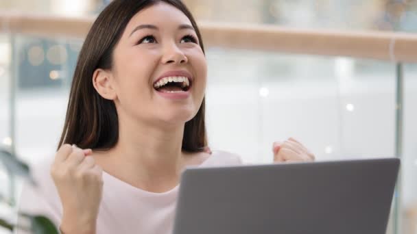 Корейская азиатка с ноутбуком удача взволнованный удивлен чувствует себя очень счастливым получил университетскую стипендию выиграть онлайн аукцион победу эмоции победительница женщина отпраздновать триумф крик с радостью достижения - Кадры, видео