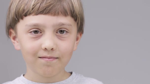 A 9 éves kaukázusi fiú azt mutatja, hogy mosolyog a hüvelykujjával - Felvétel, videó