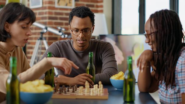 Portrait of african american man playing chess game with friends - Photo, Image