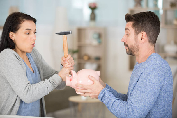 couple poised to smash piggybank with a hammer - Φωτογραφία, εικόνα