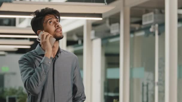 Νέοι Ινδοί επιχειρηματίας αρσενικό επενδυτή Millennial εργαζόμενος κάνουν επαγγελματική κλήση μιλώντας από κινητό τηλέφωνο στο γραφείο κρατήσει απομακρυσμένη συνομιλία πελάτη υποστήριξης σε smartphone κινητό τεχνολογία επαγγελματική επικοινωνία - Πλάνα, βίντεο