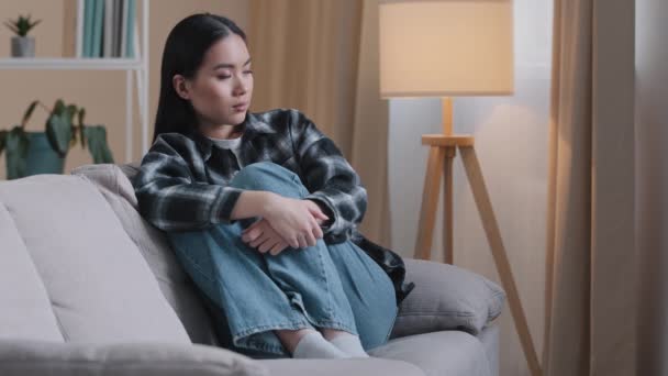 Yalnız başına üzgün, düşünceli Asyalı kadını üzen, hayal kırıklığına uğramış, evde oturup sorunları düşünen, sorunlu, kötü ruh halinde, kalbi kırık, erkek arkadaşı PMS sendromuyla kavga eden bir kız. - Video, Çekim