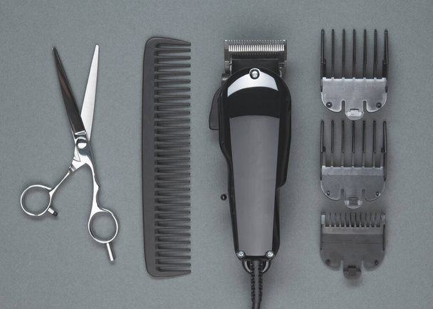 Scissors, Comb, Hair clipper. Professional barber hair clipper and shears for Man haircut. Hairdresser salon equipment. Premium hairdressing Accessories. Top view flat lay on gray background - Foto, Imagen