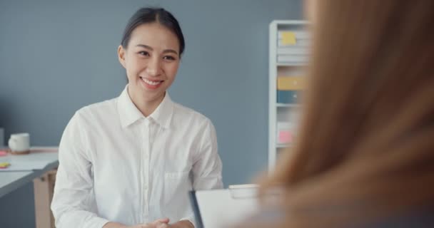 Junge asiatische Geschäftsfrauen Bewerberinnen bestehen Vorstellungsgespräch für Unternehmenspositionen oder während eines Geschäftstreffens am Schreibtisch am Arbeitsplatz sitzend. Bewerber bei Vorstellungsgespräch einstellen. - Filmmaterial, Video