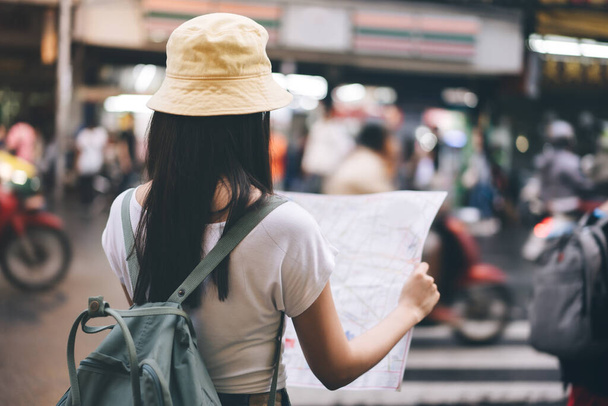 Jeune adulte asiatique voyageur heureuse femme solo sac à dos. Explorez la carte de recherche à partir d'informations sur voyage. Lorsque vous visitez la ville historique Yaowarat Chine nourriture de rue de la ville. Bangkok City, Thaïlande - Photo, image